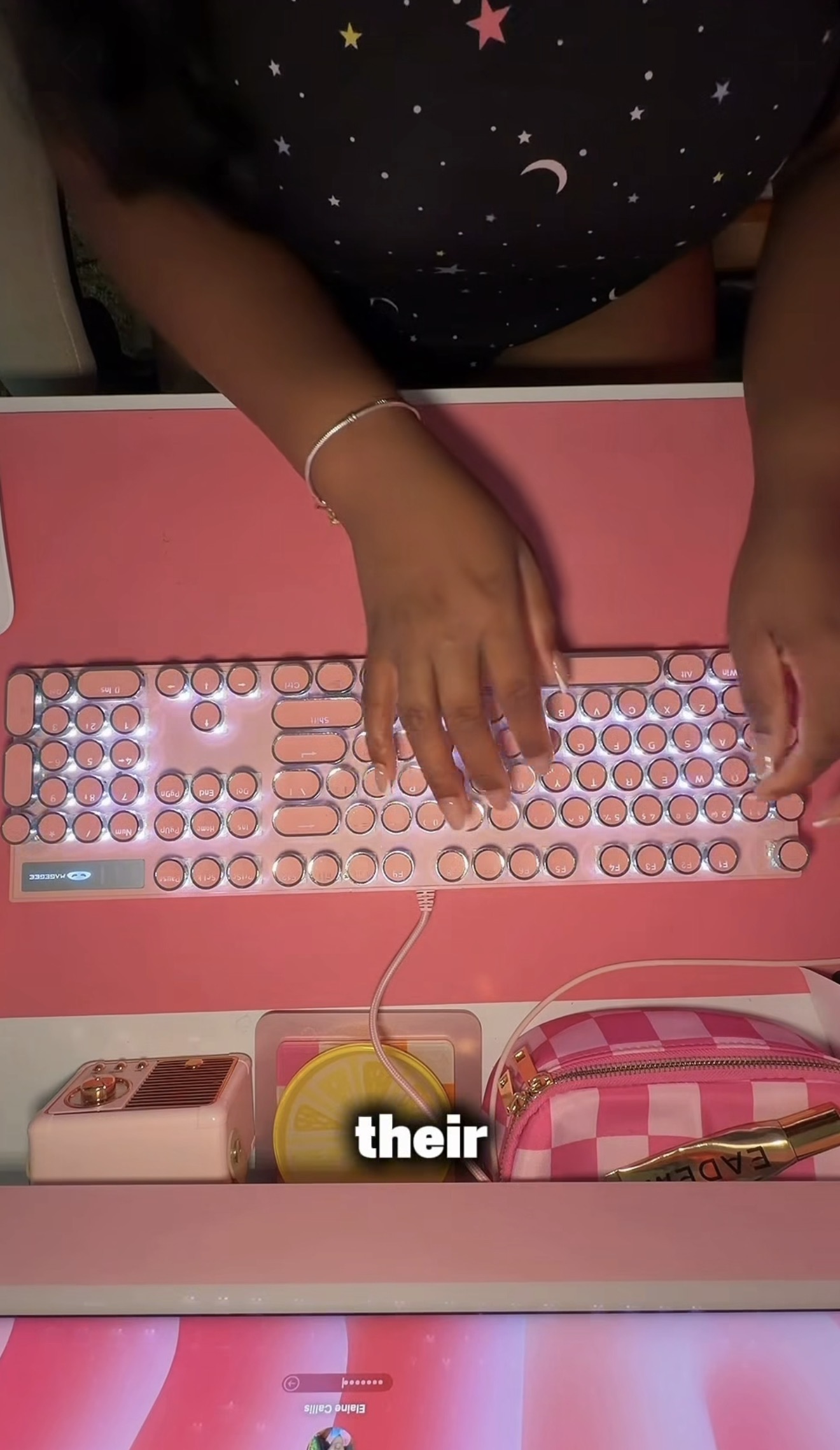 High angle overview shot looking down at hands typing on a pink keyboard