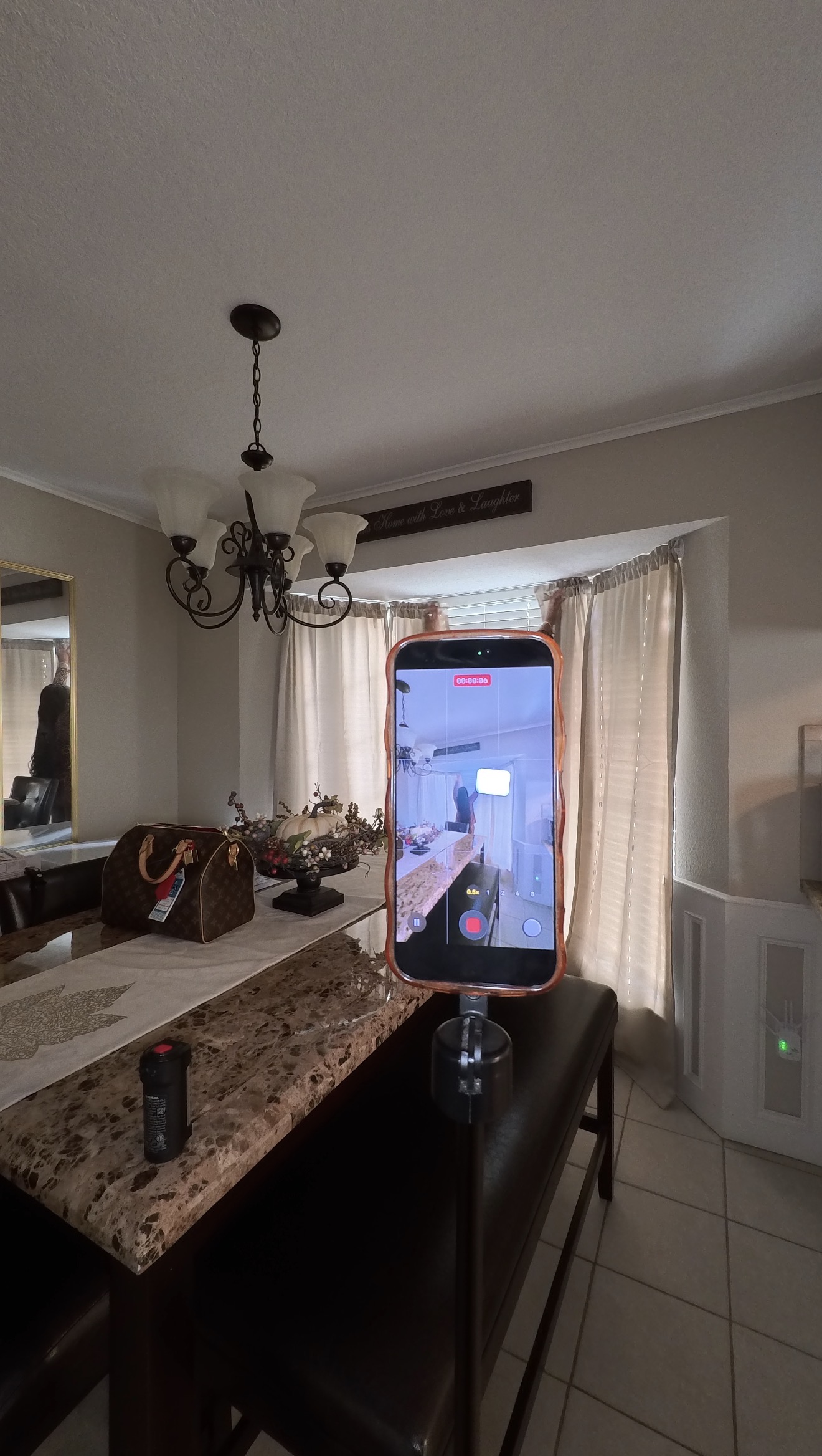 Phone on tripod set up across the room to film a curtain-opening shot in the dining area